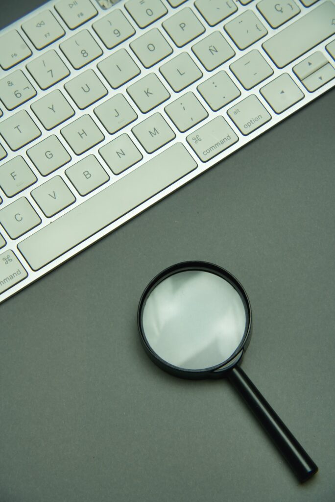 Magnifying glass and laptop keyboard. Seo.
